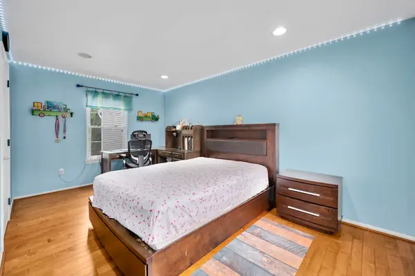 Bright blue bedroom with bed and desk